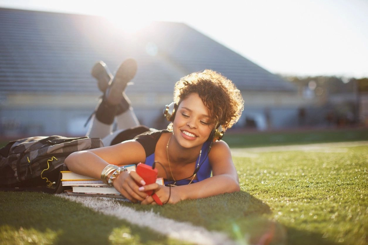 A woman laying on the grass with headphones